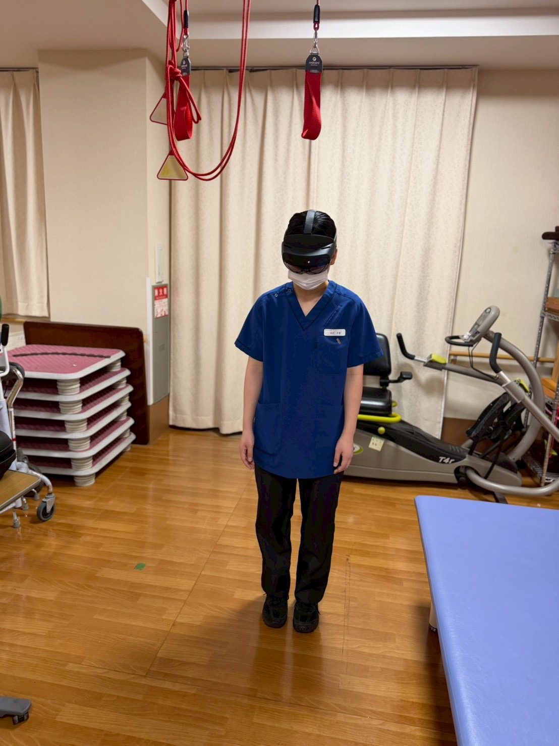 リハまるを装着して立位で体験するスタッフ